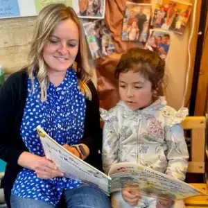 woman reading to kindergarten child