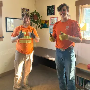 Two men helping move a desk